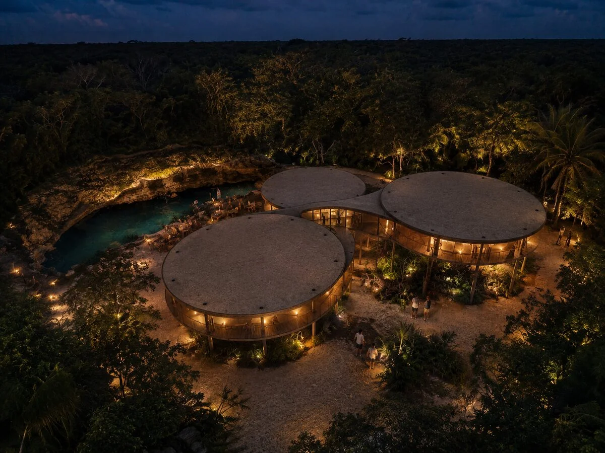 Vista aérea nocturna de los pabellones junto a un cenote en Selvadentro, en la Ruta de los Cenotes de Tulum